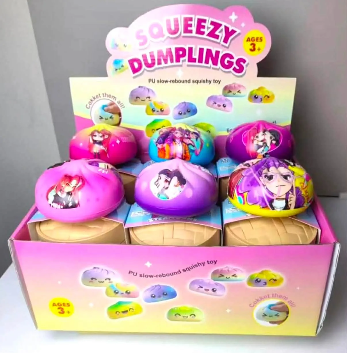 Un second présentoir de jouets à presser, aux couleurs rose et mauve, illustré de personnages.